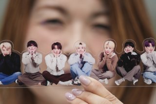 Une fan de groupe de K-pop BTS pose avec une photo de la formation. KEYSTONE/AP/Lee Jin-man